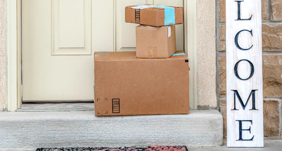 Packages on the doorstep of a home with a welcome sign in Bend